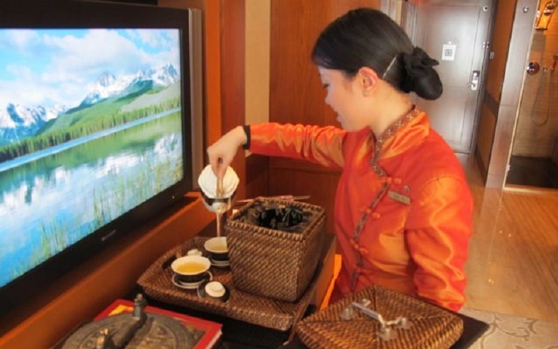 Nhân viên pha trà nóng phục vụ cho khách hàng tại khách sạn